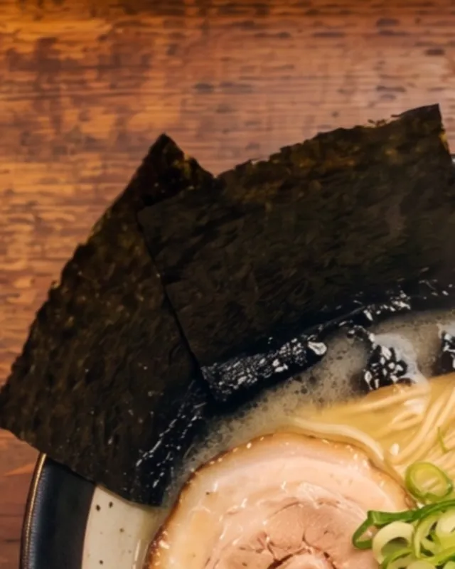 Dark sheets of nori standing at the rim of the bowl